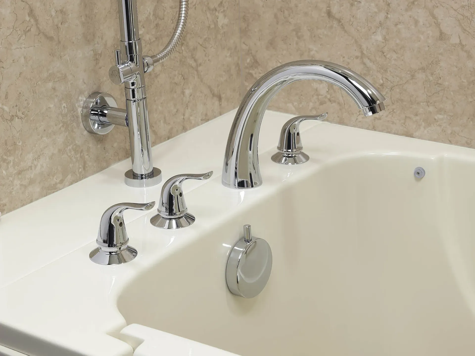 A close-up of polished chrome fixtures on a white bathtub.